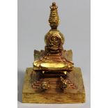 Stupa.Feuervergoldete Bronze. Quadratischer, getreppter Sockel mit baldachinartigem Dach, darüber