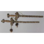 Zwei Münzschwerter.Amulette in Form von Schwertern aus 60 bzw. 63 Bronzemünzen der verschiedenen