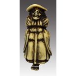 Netsuke.Hirschhorn. Darstellung eines stehenden Holländers mit breitkrämpigem Hut und Stock in der