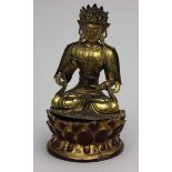 Guanyin-Skulptur.Feuervergoldete Bronze. Die Gottheit ruht mit übereinandergeschlagenen Füßen, trägt