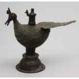 Öllampe.Bronze mit alter Patina. Gestaltet in Form eines Pfaus auf glockenförmigem Fuß mit