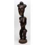Skulptur, Baule.Braunes Holz mit dunkler Patinierung. Auf einem runden Sockel stehende, weibliche