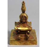 Stupa.Feuervergoldete Bronze. Quadratischer, getreppter Sockel mit baldachinartigem Dach, darüber