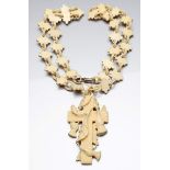 Halskette mit Kreuzanhänger.Elfenbein, geschnitzt. Kreuz mit Holzmaserung und umlaufend blühendem