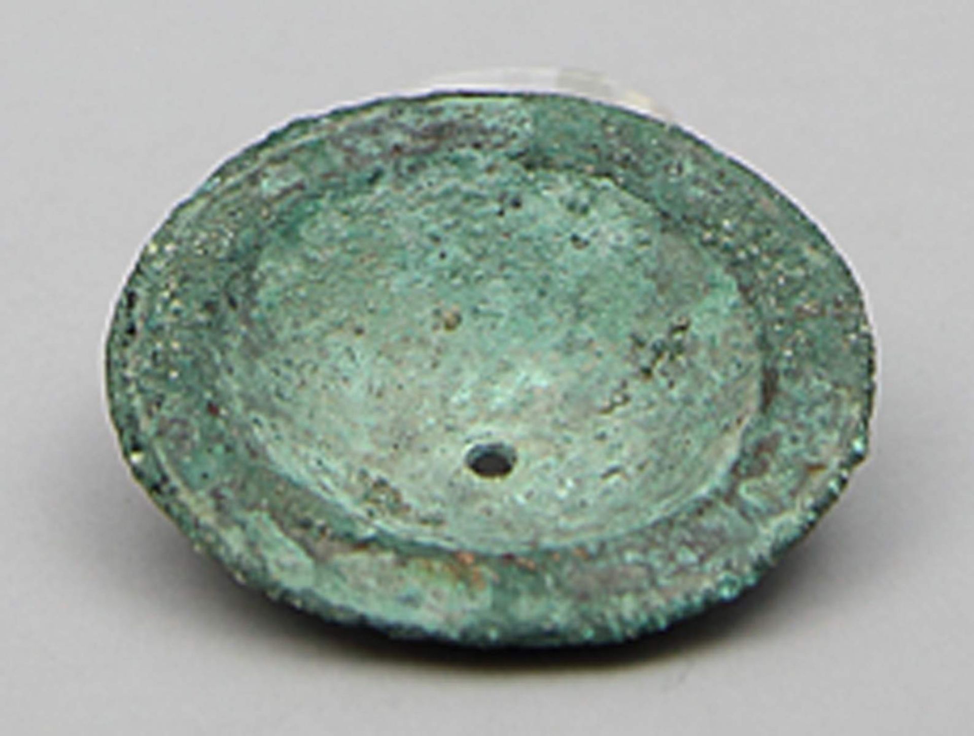 Antike Zimbel.Bronze mit verkrusteter, grüner Patina. Rund mit mittiger Wölbung und Bohrung für