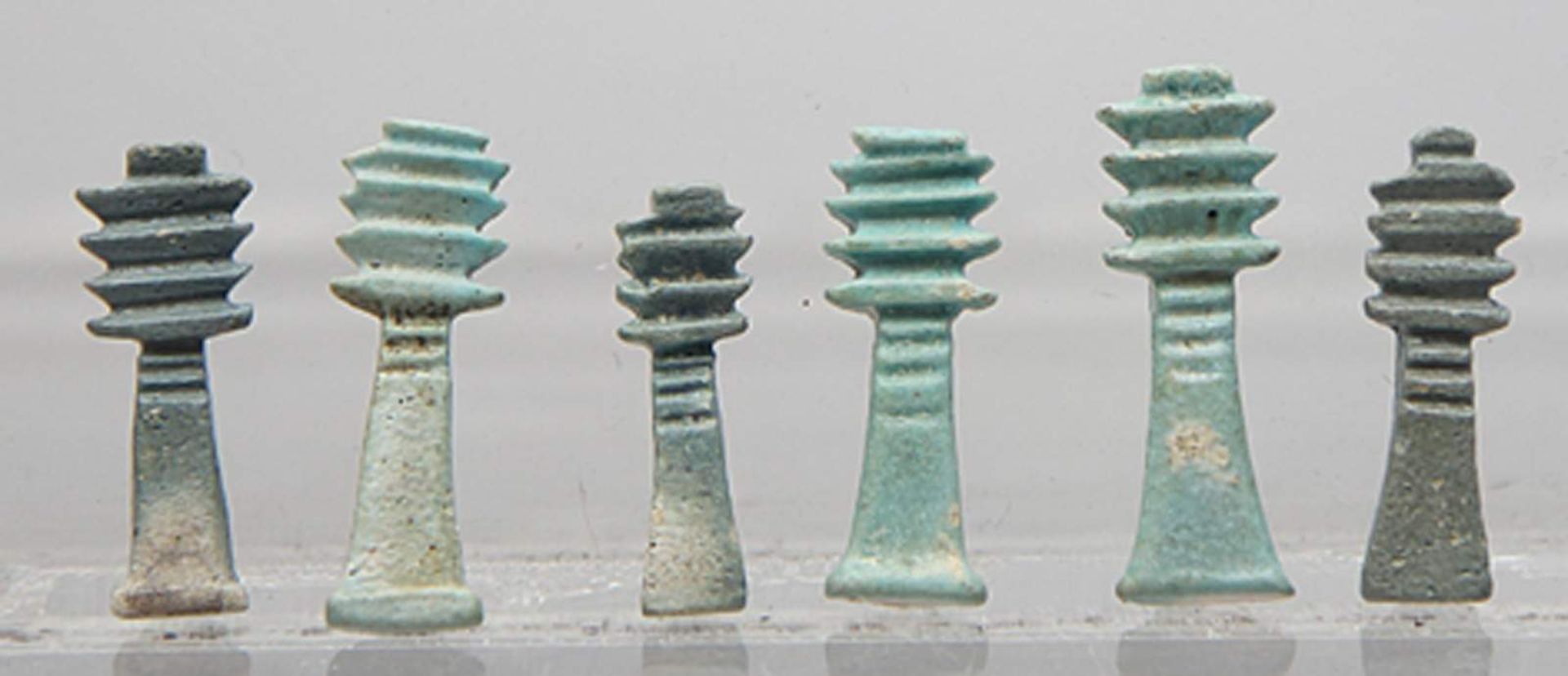 Sechs Djed-Pfeiler-Amulette.In verschiedenen Türkistönen glasierte Fayence. Je mit horizontaler