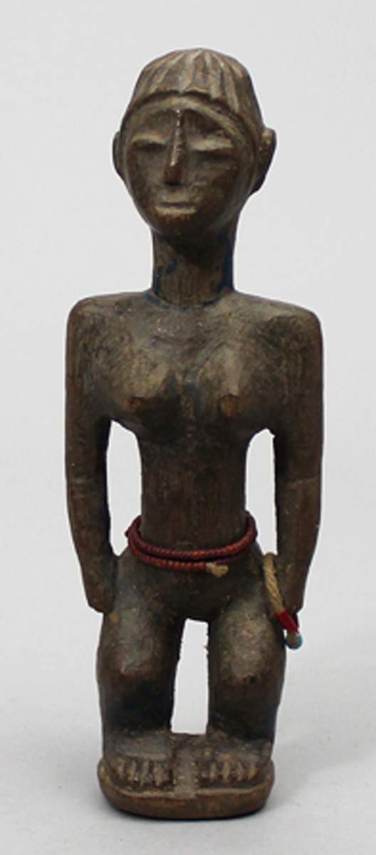 Weibliche Puppe, Ewe.Dunkelbraunes Holz. Auf einer Sockelplatte stehende Figur mit an den Seiten