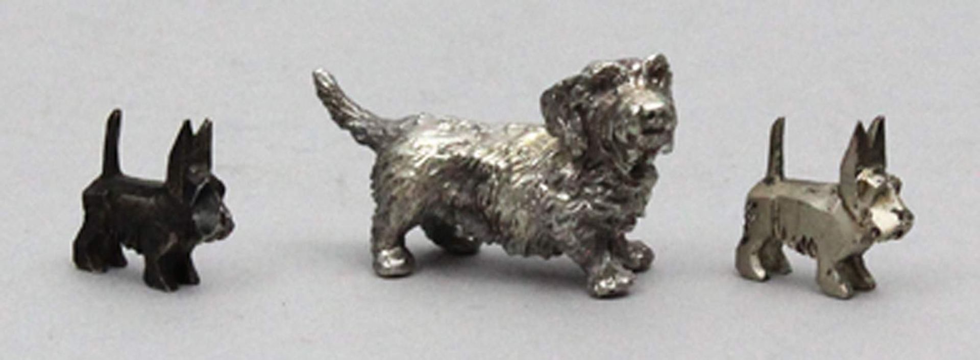 Drei Hundeskulpturen.Massives 935/000 Silber, zus. 120 g. 20. Jh. H. 2,5 bis 4, L. 3 bis 5,5 cm.