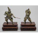 Paar Samurai-Skulpturen in kämpfender Pose.Bronze mit Restpatinierung. Jeweils kalligraphisch