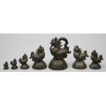 Sieben Opiumgewichte.Bronze. Verschiedene Formen von Singhalöwen, das größte Ex. mit Griff. Teils