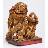 Tempellöwengruppe, China um 1900.Holz geschnitzt, rot gelackt u. vergoldet. Sitzen- der gr. Löwe,