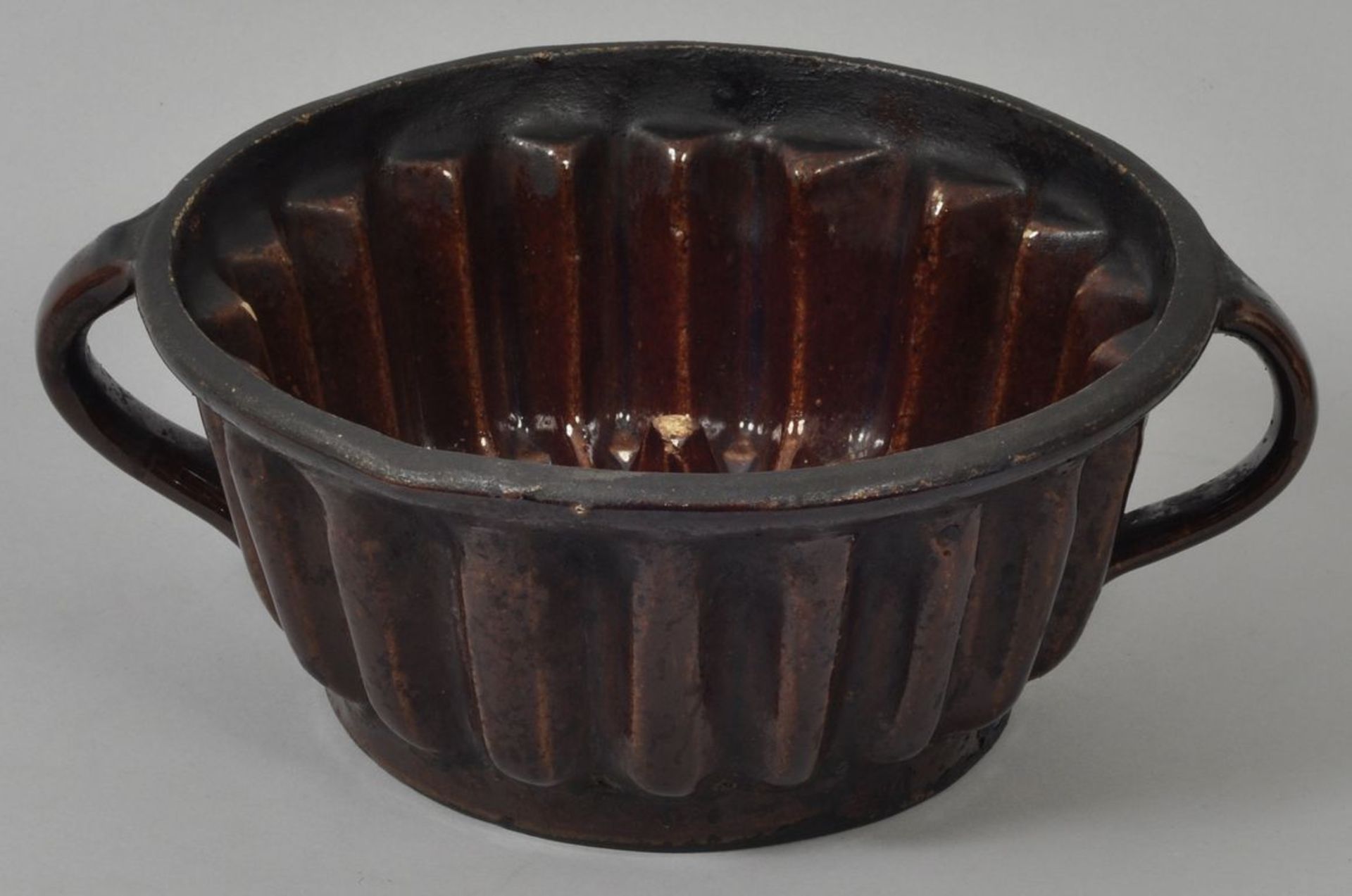 Gugelhupfform, 19./Anf. 20. Jh.Keramik/Steinzeug, braune Glasur. Runde Form mit geraden Rippen,