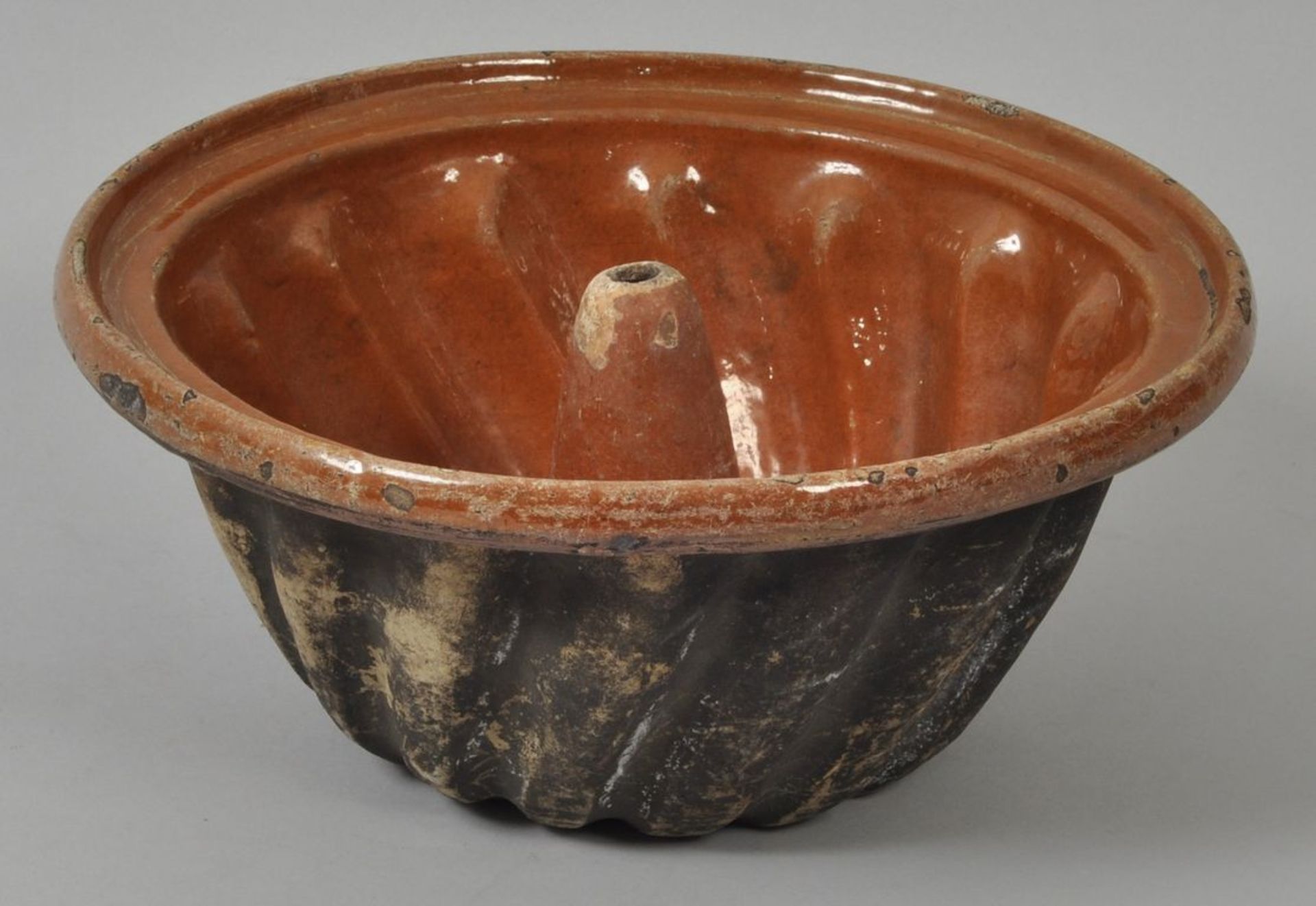 Gugelhupfform, 19./Anf. 20. Jh.Keramik/Irdenware, Fond hellbraun glasiert. Runde Form mit