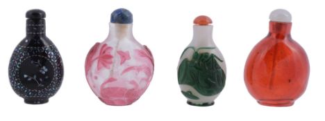 A group of four snuff bottles including two overlay pink and green glass...  A group of four snuff