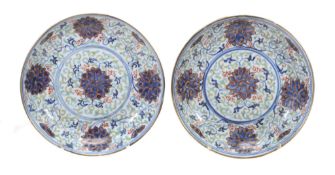 A pair of saucer dishes each of shallow, circular form decorated in...  A pair of saucer dishes
