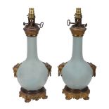 A pair of French celadon glazed china and gilt bronze mounted urns fitted as...  A pair of French