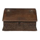 A Charles II oak bible box, dated 1667, with a sloping moulded hinged top...  A Charles II oak bible