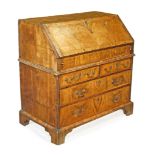 A George I walnut bureau , circa 1720, rectangular fall opening to a fitted...  A George I walnut