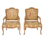 A pair of carved beech and needlework upholstered armchairs in the Louis XV...  A pair of carved