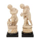 A pair of Continental sculpted alabaster and onyx mounted models of putti  A pair of Continental