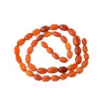 A graduated amber bead necklace , the forty three oval amber beads measuring...  A graduated amber