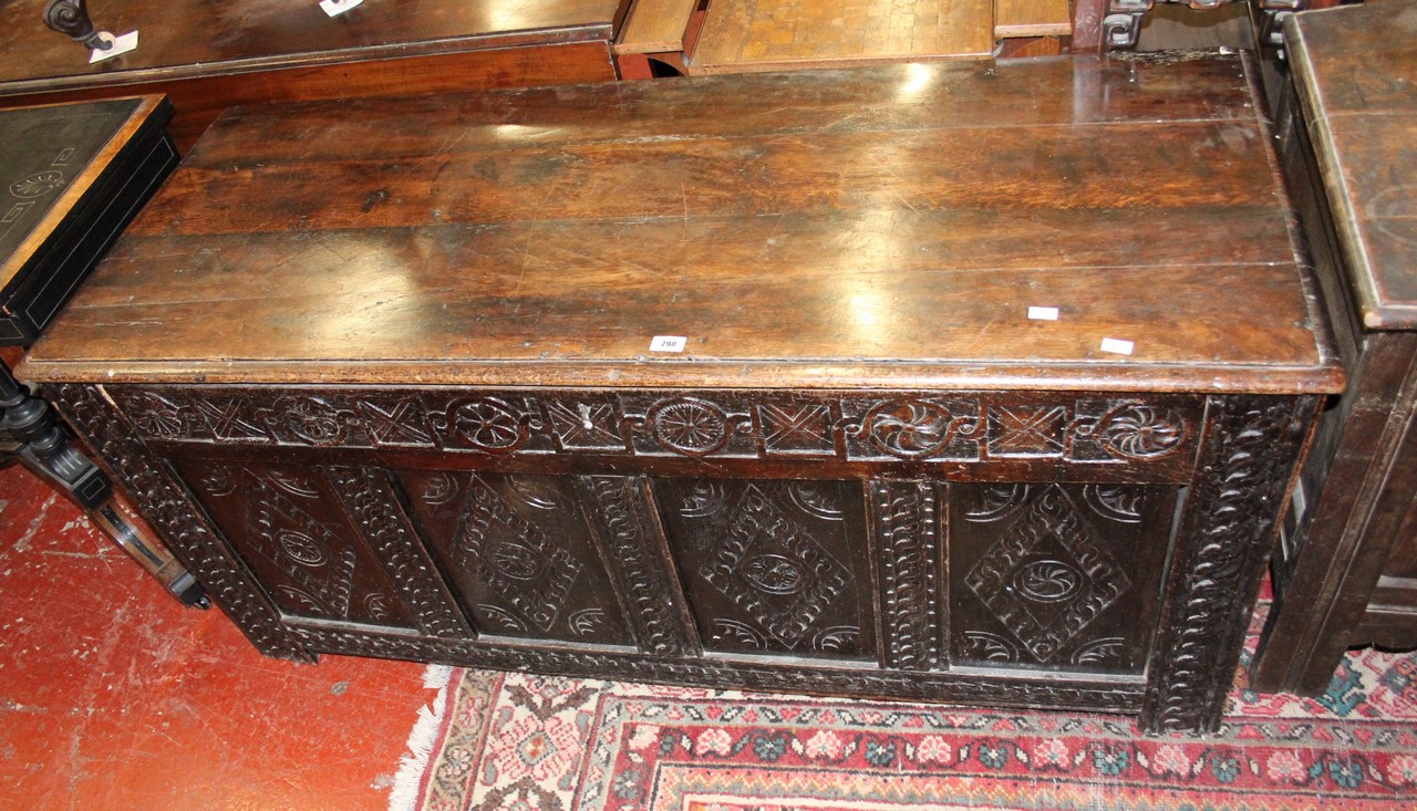 An 18th century oak coffer with profusely carved front panels.