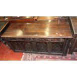 An 18th century oak coffer with profusely carved front panels.