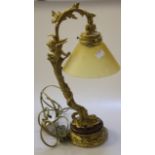 A gilt metal table lamp with glass shade, foliate decorated on circular plinth base, 40cm high