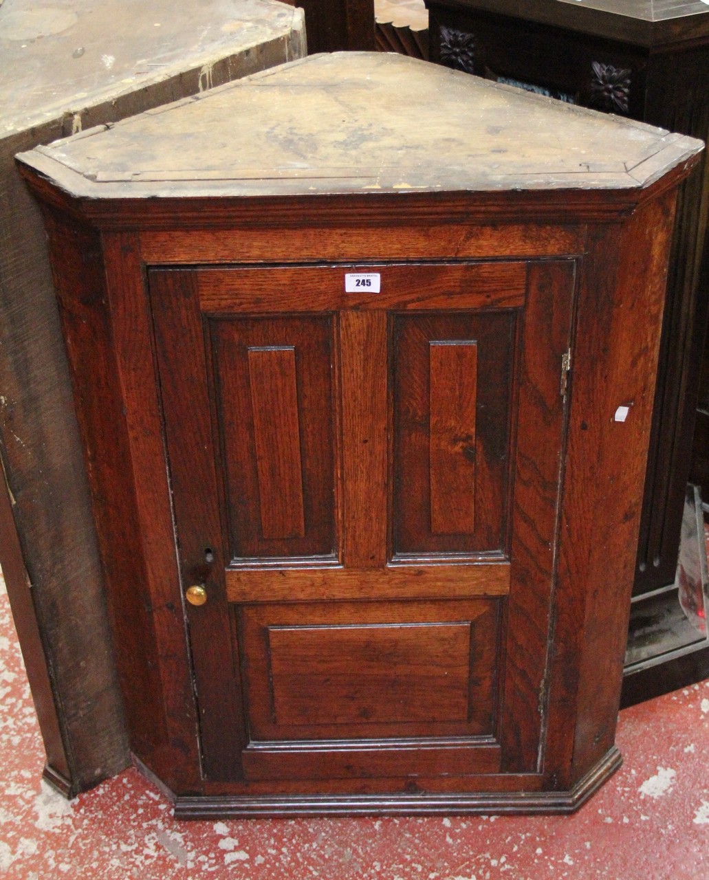 A George III oak hanging corner cupboard with glazed doors and another with panelled doors.