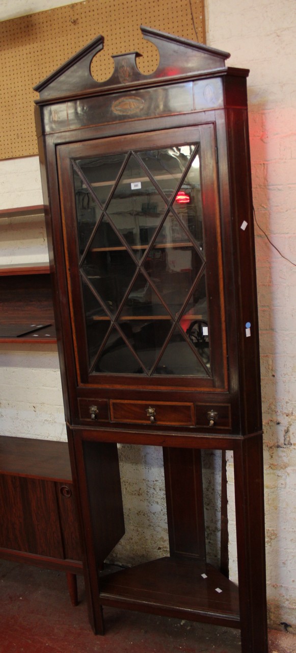 An Edwardian mahogany glazed corner cabinet.