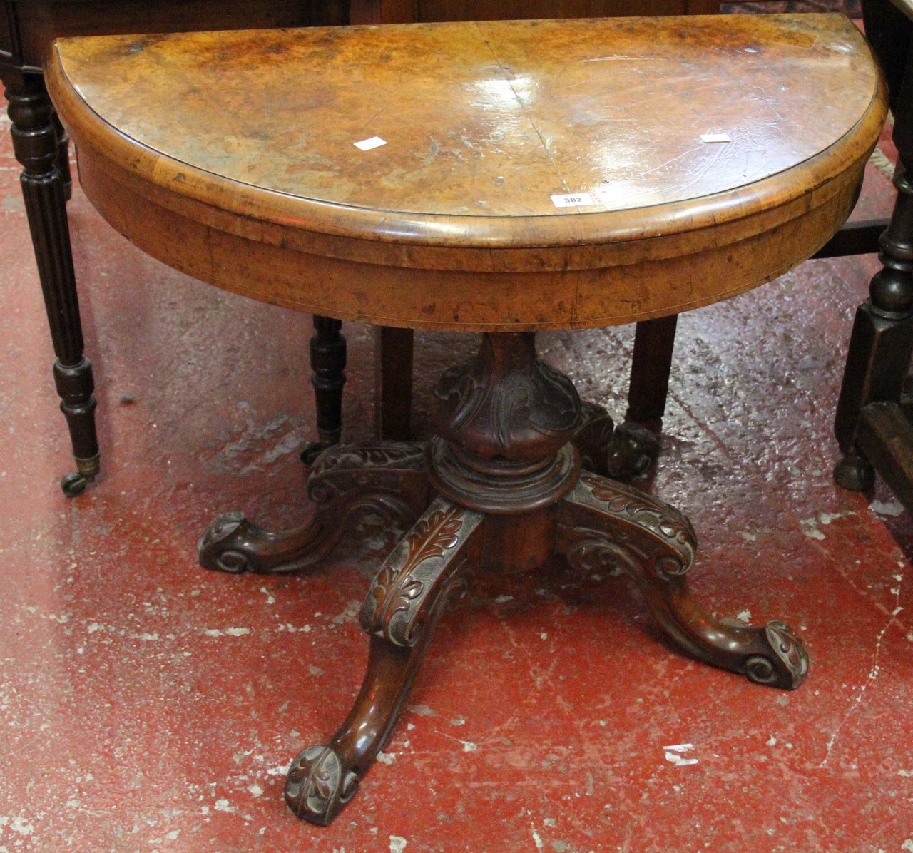 A Victorian walnut demi lune foldover card table.Best Bid