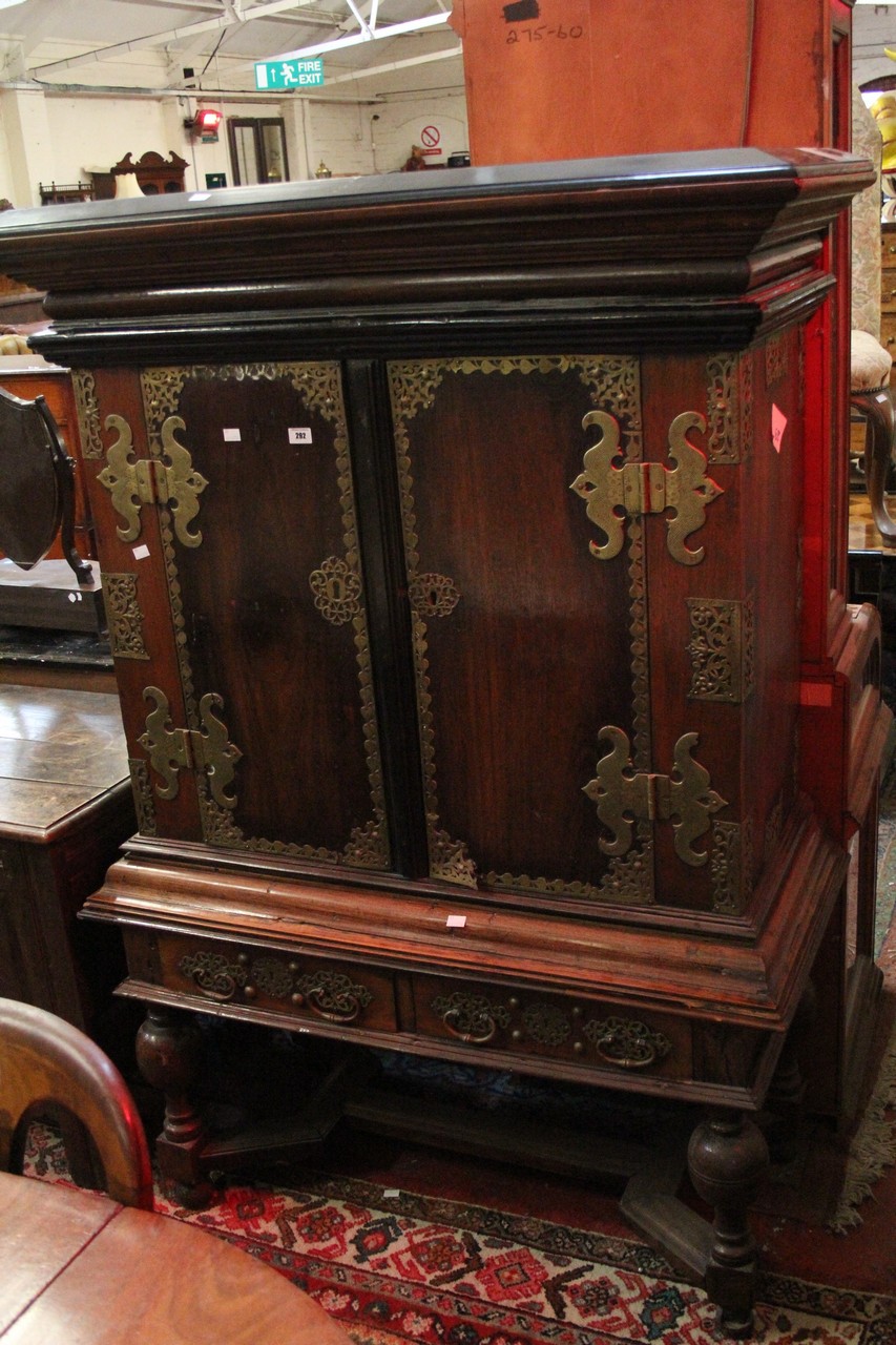 A 19th century Dutch Colonial cabinet on stand with intricate brass overlay to the doors.