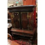 A 19th century Dutch Colonial cabinet on stand with intricate brass overlay to the doors.
