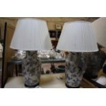 A pair of modern Oriental blue and white ceramic table lamps, on wooden bases, with white shades,