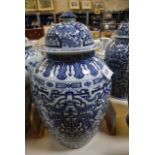 A pair of modern Chinese blue and white ceramic vases with covers, baluster shaped, foliate