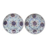 A pair of saucer dishes each of shallow, circular form decorated in...  A pair of saucer dishes