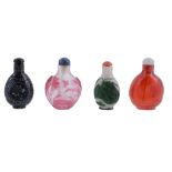 A group of four snuff bottles including two overlay pink and green glass...  A group of four snuff