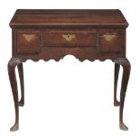 A George II oak lowboy, circa 1750, with a crossbanded and moulded...  A George II oak lowboy,