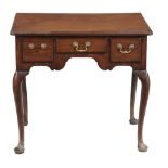 A George II walnut lowboy, circa 1750, the moulded top with three short...  A George II walnut