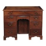 A George II mahogany kneehole desk circa 1740 with a rectangular top  A George II mahogany