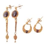 A pair of gold and garnet earrings , the cabochon garnets within a twisted... A pair of gold and
