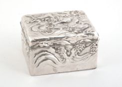A Japanese silver coloured cigarette box, embossed with a dragon among wave...  A Japanese silver