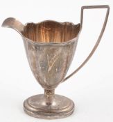 A silver helmet shape pedestal cream jug, Sheffield 1919, in George III style  A silver helmet shape