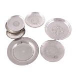 Eight silver coloured circular dishes with coin insets  Eight silver coloured circular dishes with
