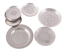 Eight silver coloured circular dishes with coin insets  Eight silver coloured circular dishes with