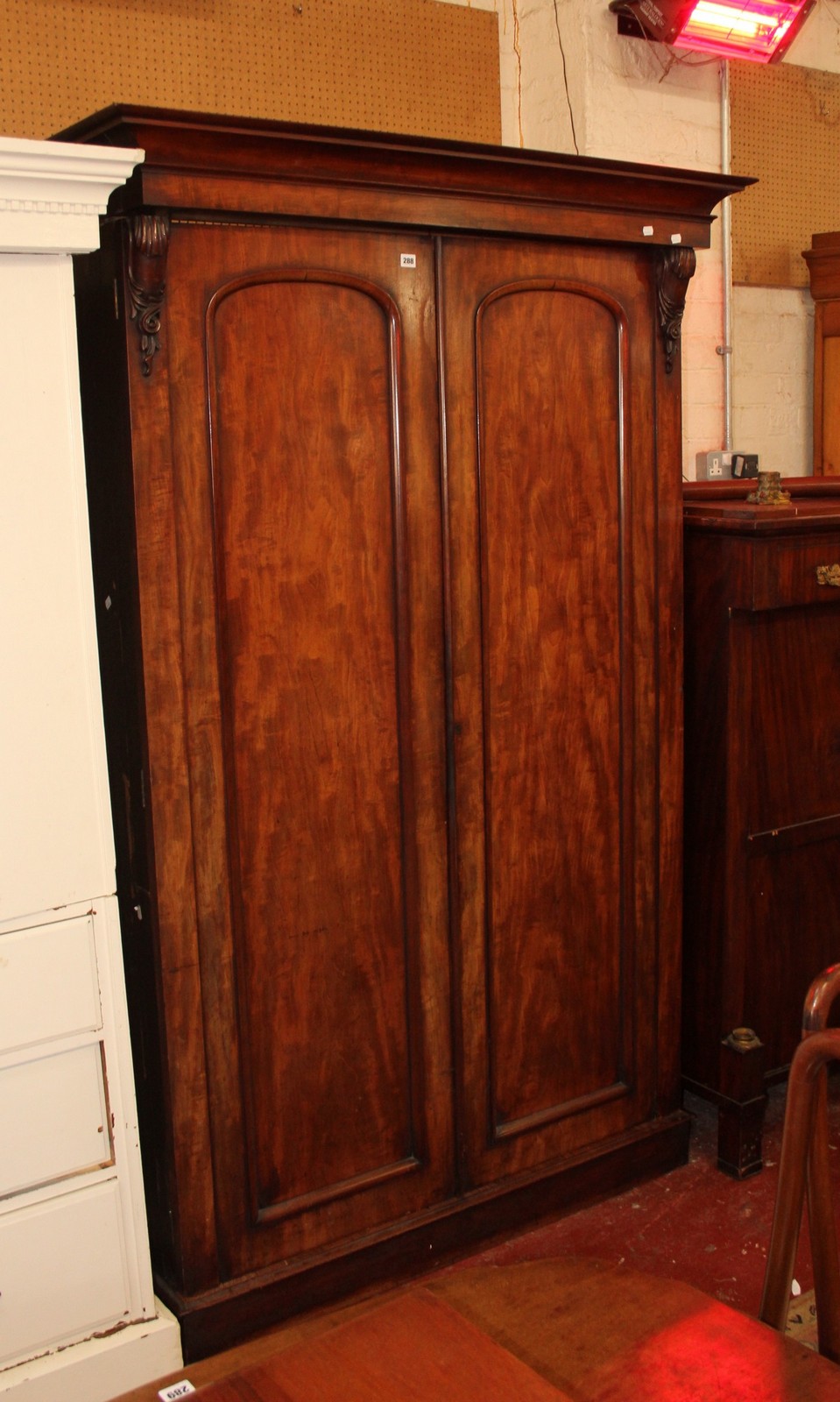 A Victorian mahogany wardrobe with two arched panelled doors.