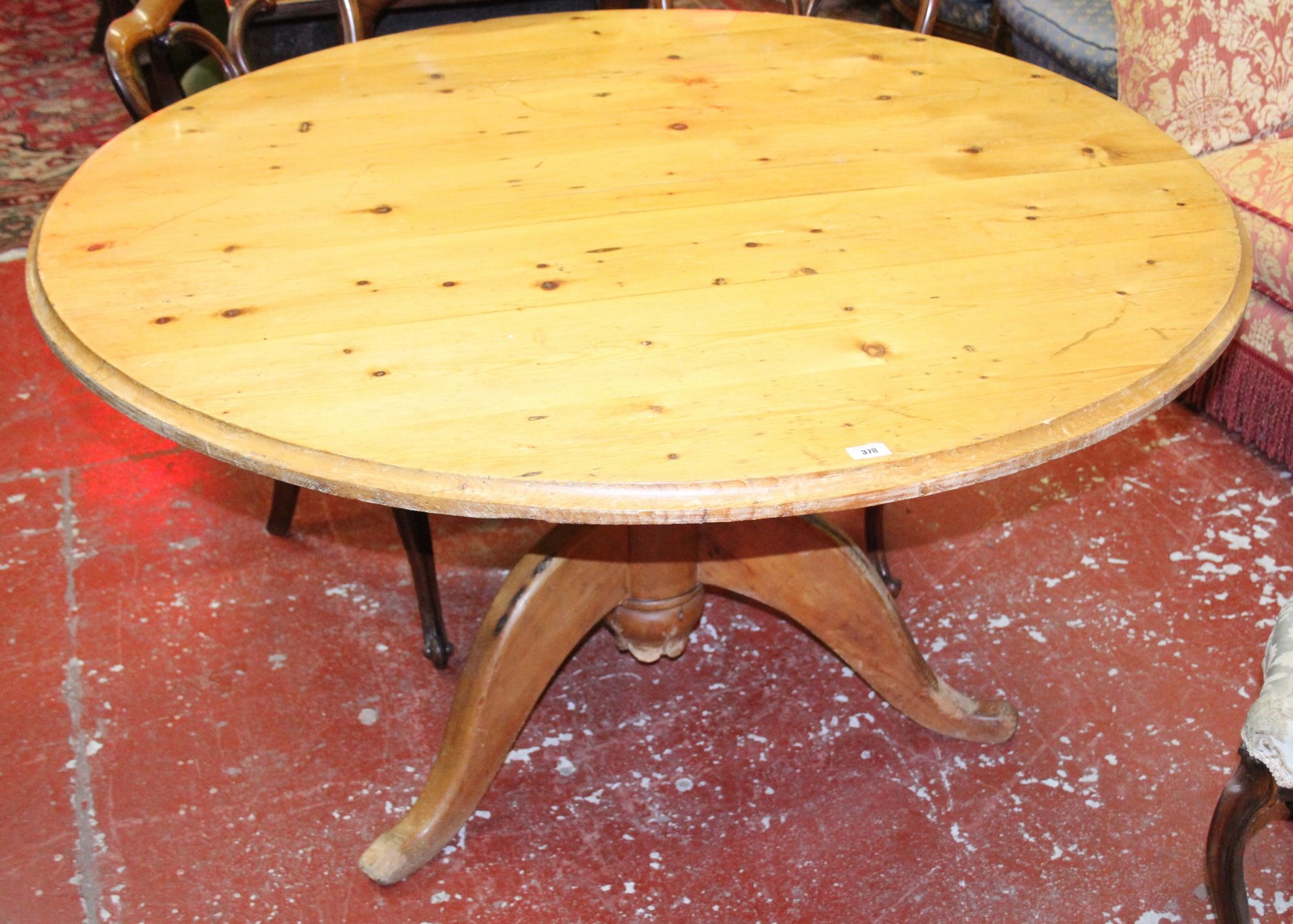 A pine circular dining table on carved column and tripod base 137cm diameter