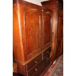 A 19th Century mahogany linen press the arched doors enclosing linen slides with two short and two