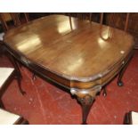A mahogany extending dining table with shell carving to the cabriole legs on ball and claw feet.
