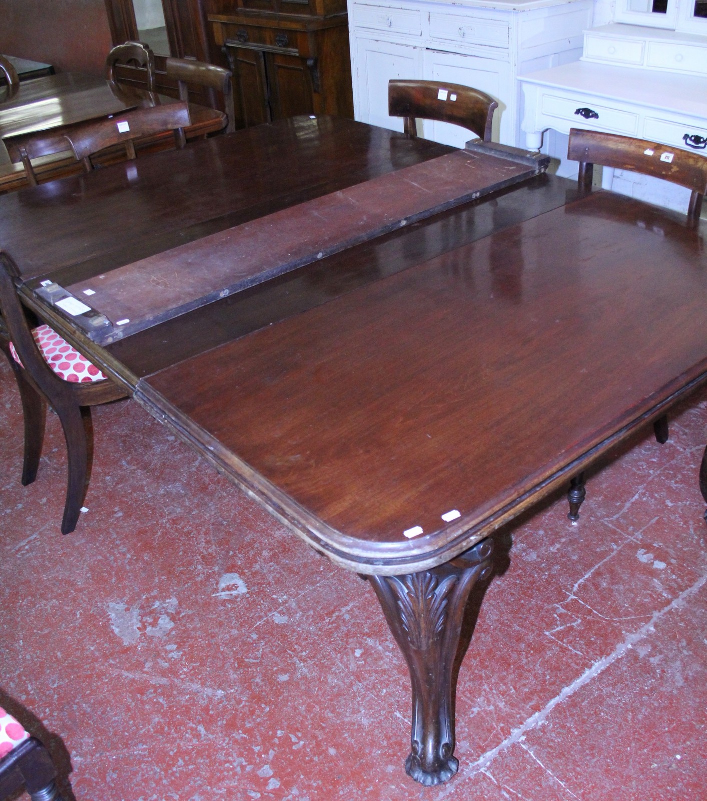 A Victorian mahogany extending dining table, on swept supports.